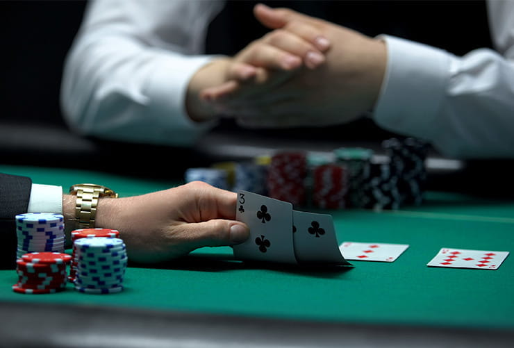 Hand Holding a Pack of Cards on a Casino Table