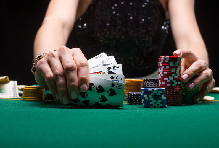 Two Hands Holding a Pack of Cards and a Pile of Chips